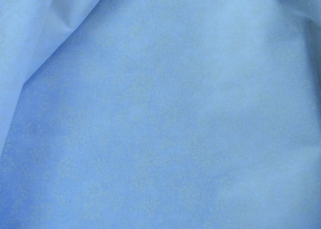 White 100% cotton with floral print in background